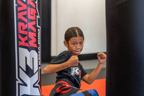 Young student holding her guard between heavy bags at K3 Martial Arts in Roseville