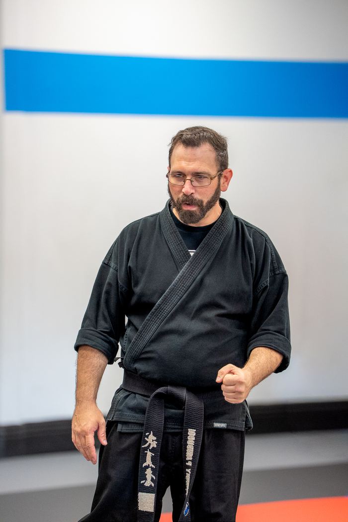 K3 Martial Arts instructor in a black gi and black belt coaching on the mat in Roseville