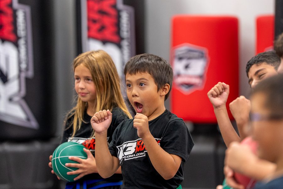 K3 students cheering with fists raised during a group class in Roseville